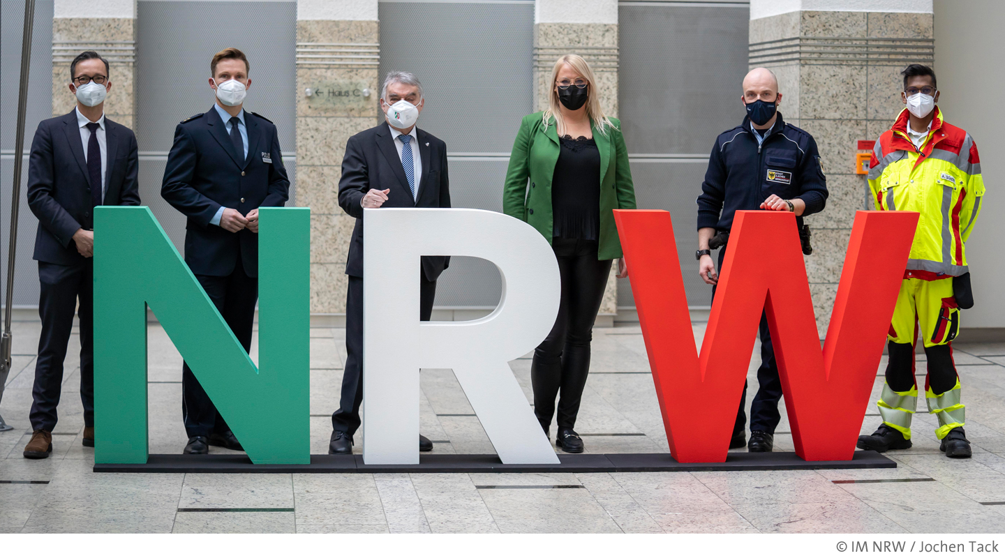 Mitgleider des Innenministerium und Nicole Schorn vor NRW-Schriftzug