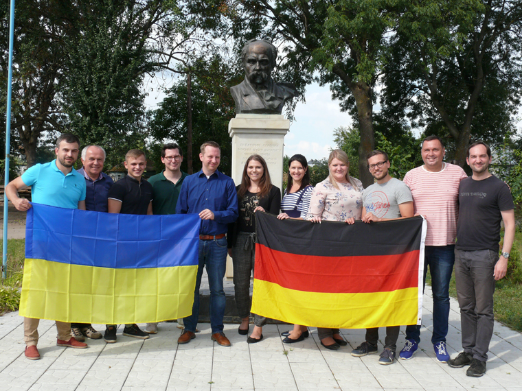 deutsch-ukrainischer Austausch steht gemeinsam mit Flaggen des Landes